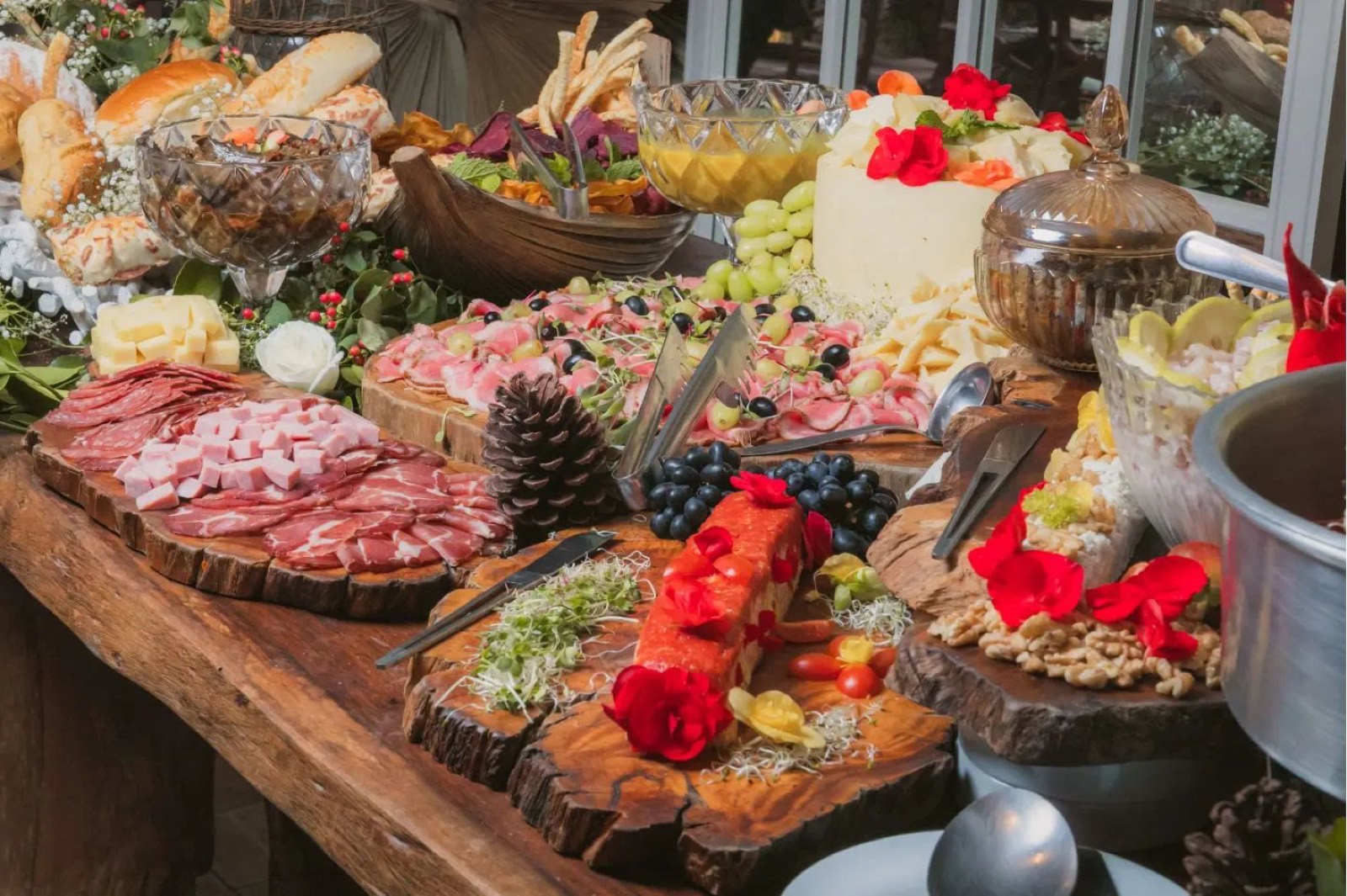 Ilha gastronômica montada com frios, pães, queijos e frutas