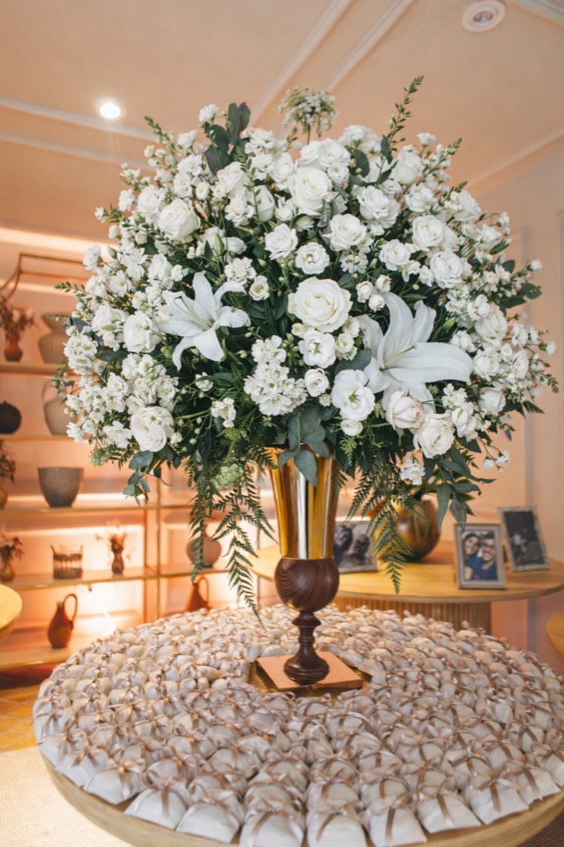 Mesa de bem-casados com arranjo de flores brancas